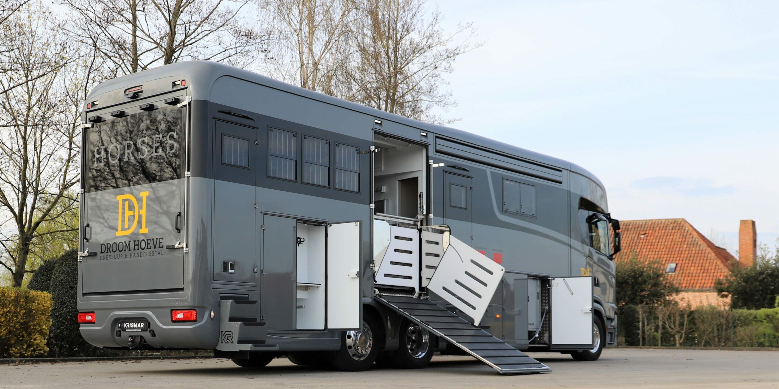 Een grijze paardenvrachtwagen van het merk Scania met optische zwarte lijn gebouwd door Krismar horse trucks.