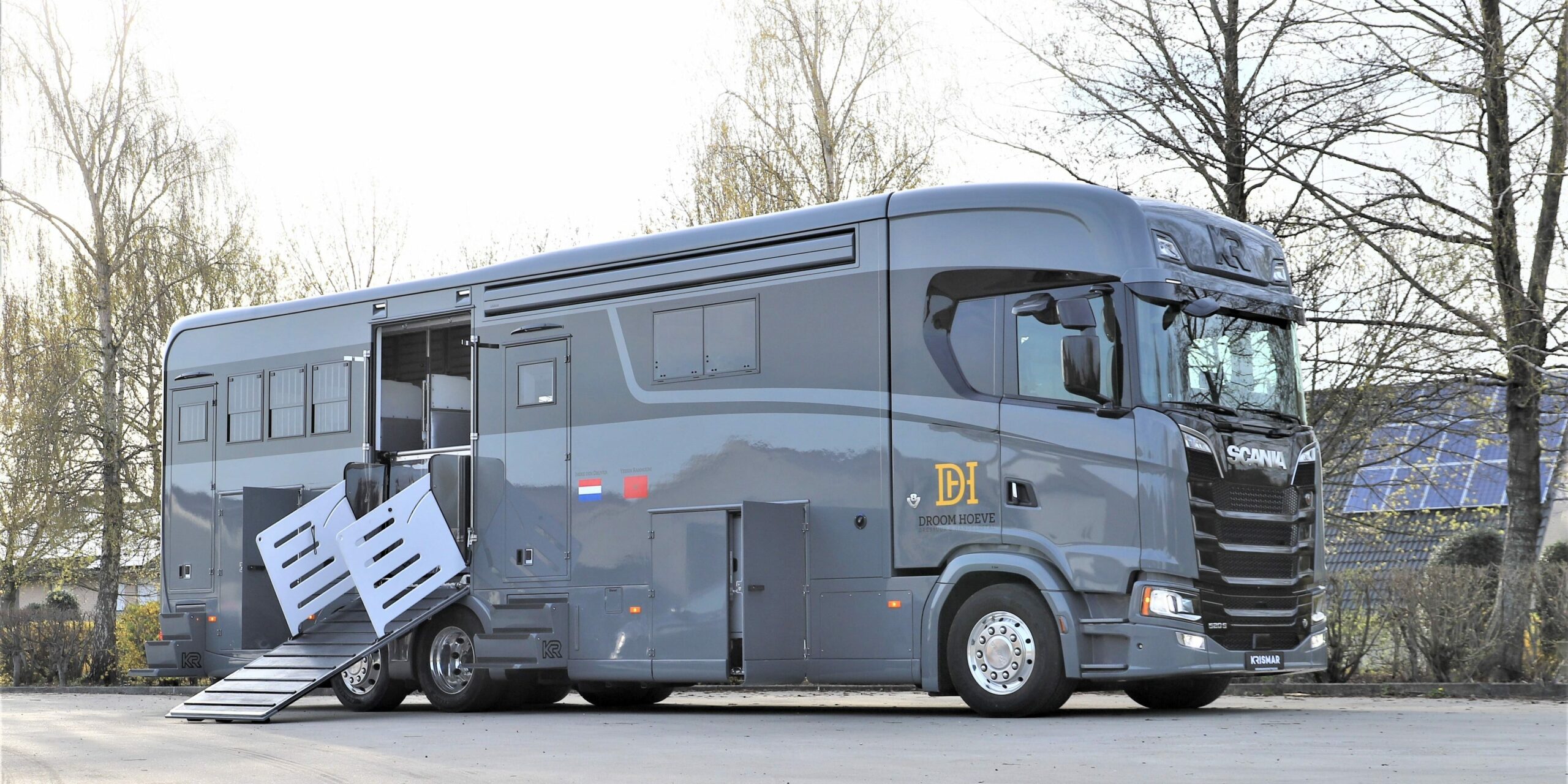 Een grijze paardenvrachtwagen van het merk Scania met optische zwarte lijn gebouwd door Krismar horse trucks.