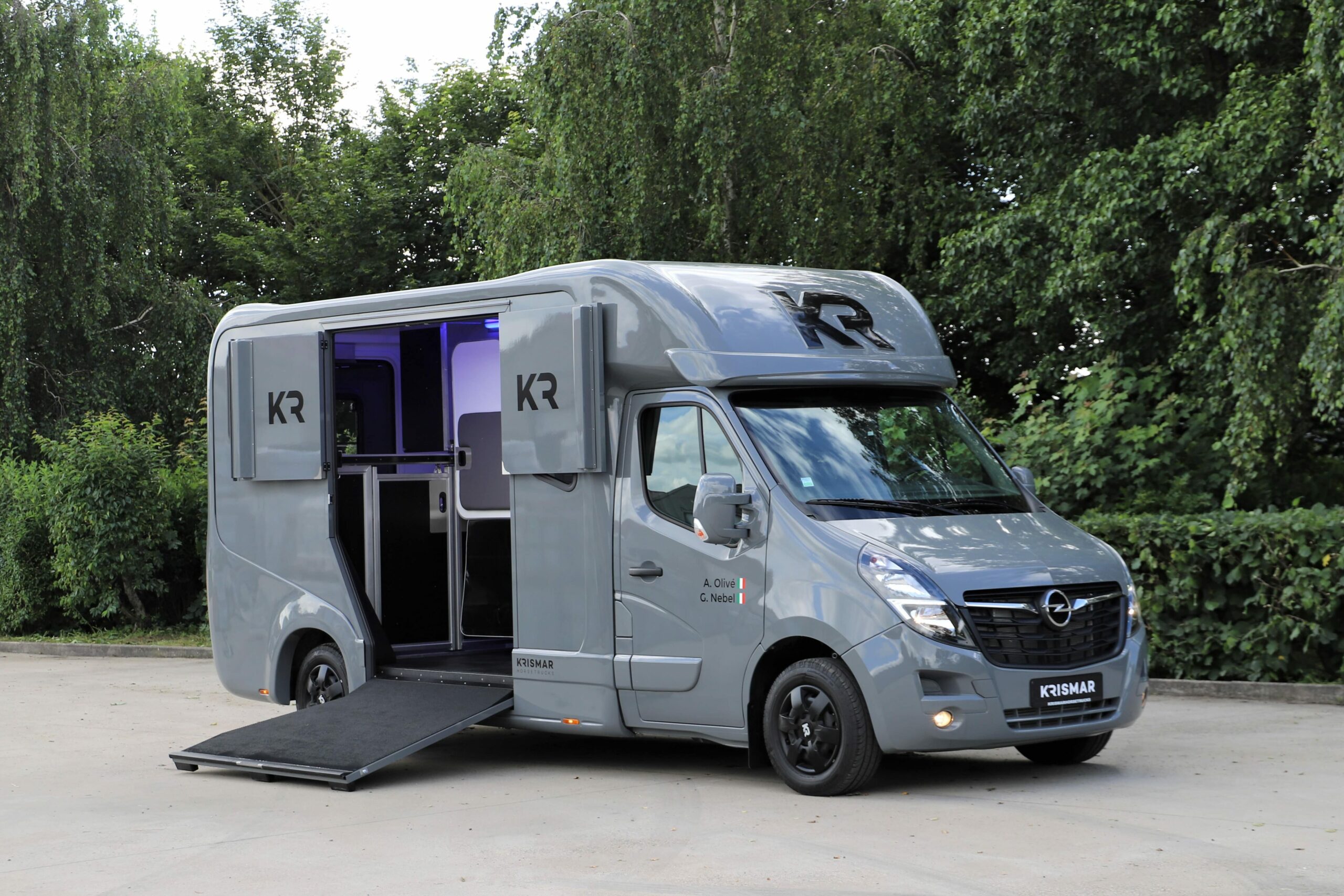 Een grijze Krismar paardenvrachtwagen voor 2 paarden gebouwd op een Opel chassis.