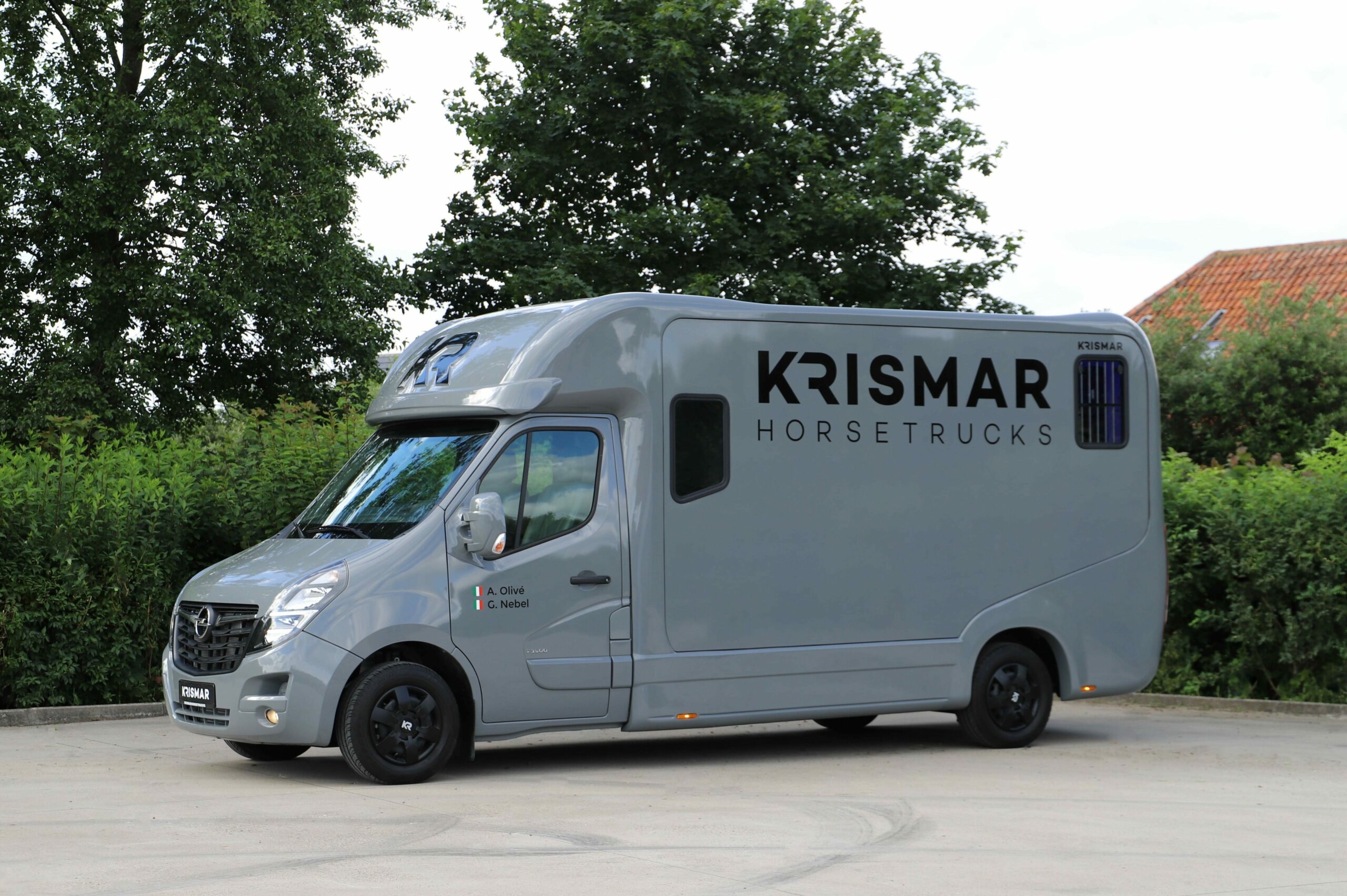 Een grijze Krismar paardenvrachtwagen voor 2 paarden gebouwd op een Opel chassis.