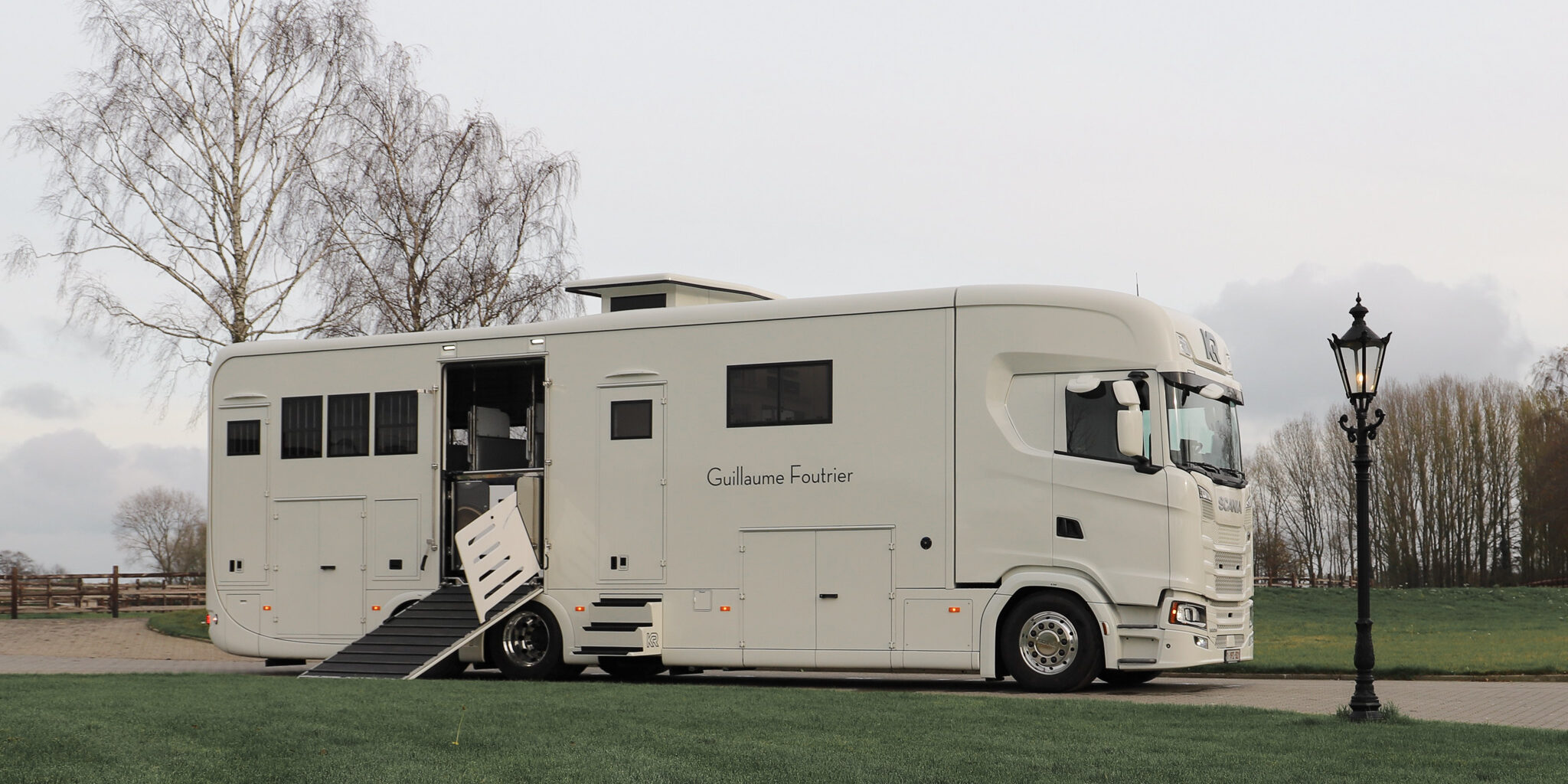 Un camion à chevaux Krismar construit sur un châssis Scania de couleur blanche