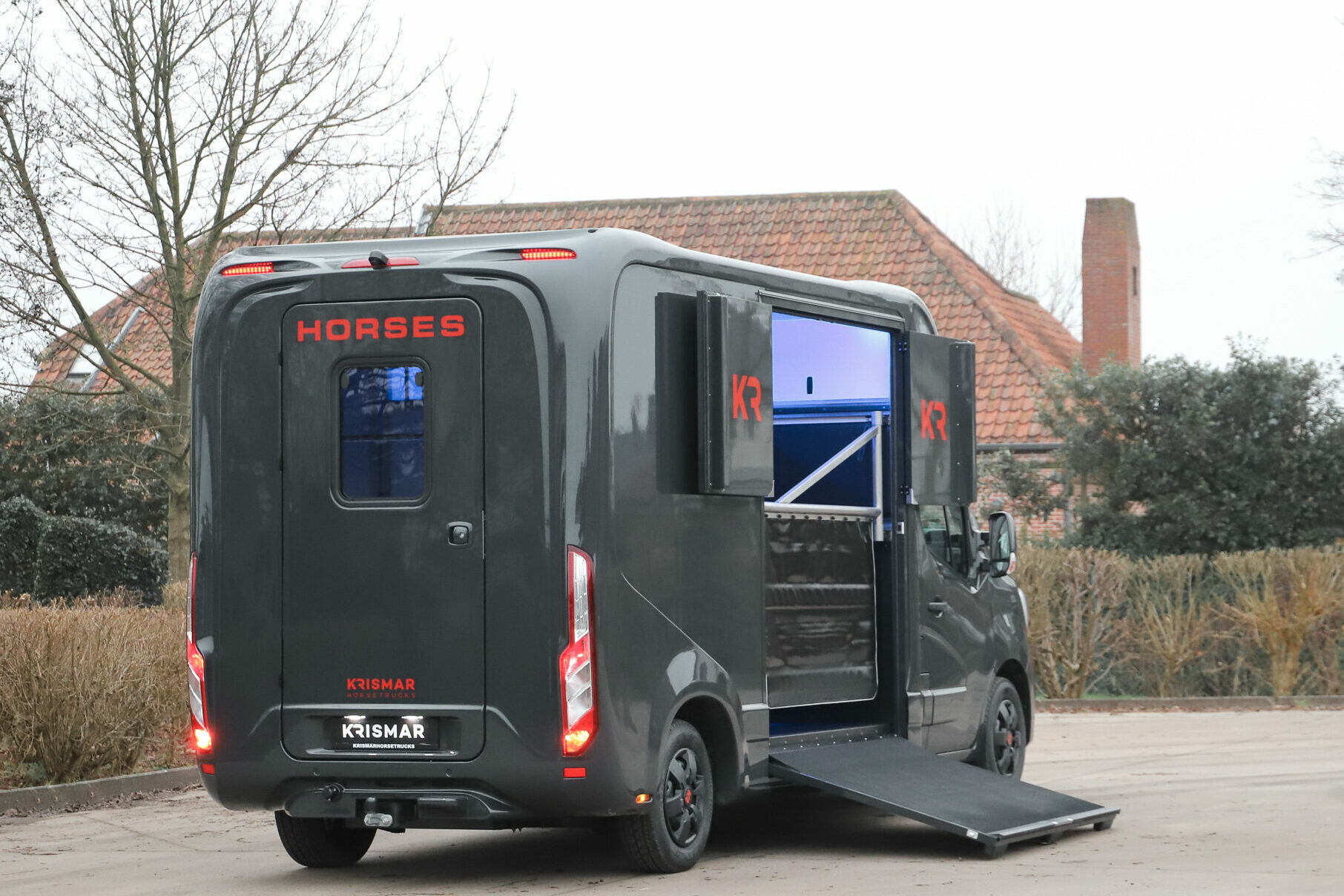 Een donkergrijs 2paards met rode details van het merk Krismar Horse Trucks.