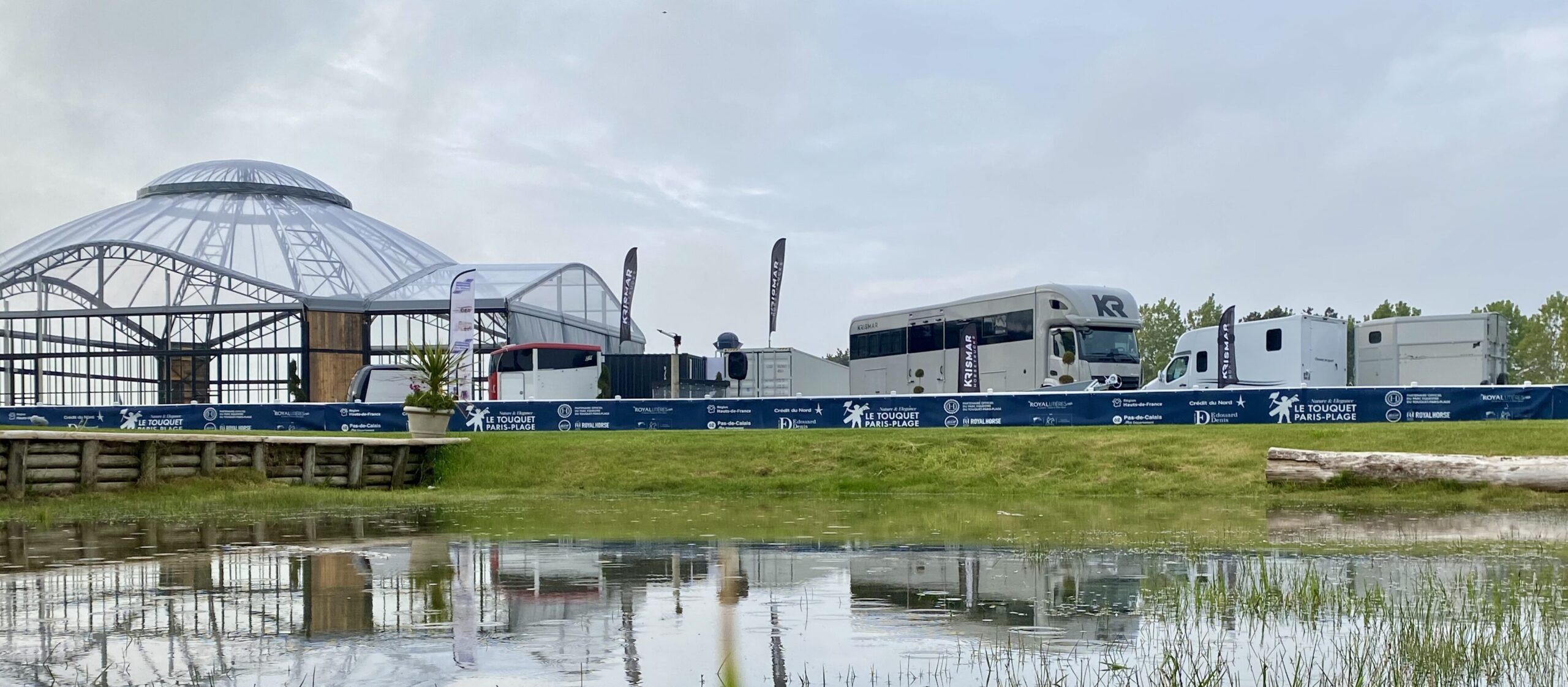 Een foto van de Krismar stand in Le Toquet genomen met een vijver tussen waardoor alles reflecteert in het water.