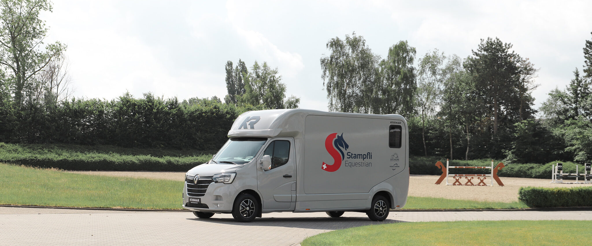 Een grijze Krismar 2-paards wagen op een Renault chassis.