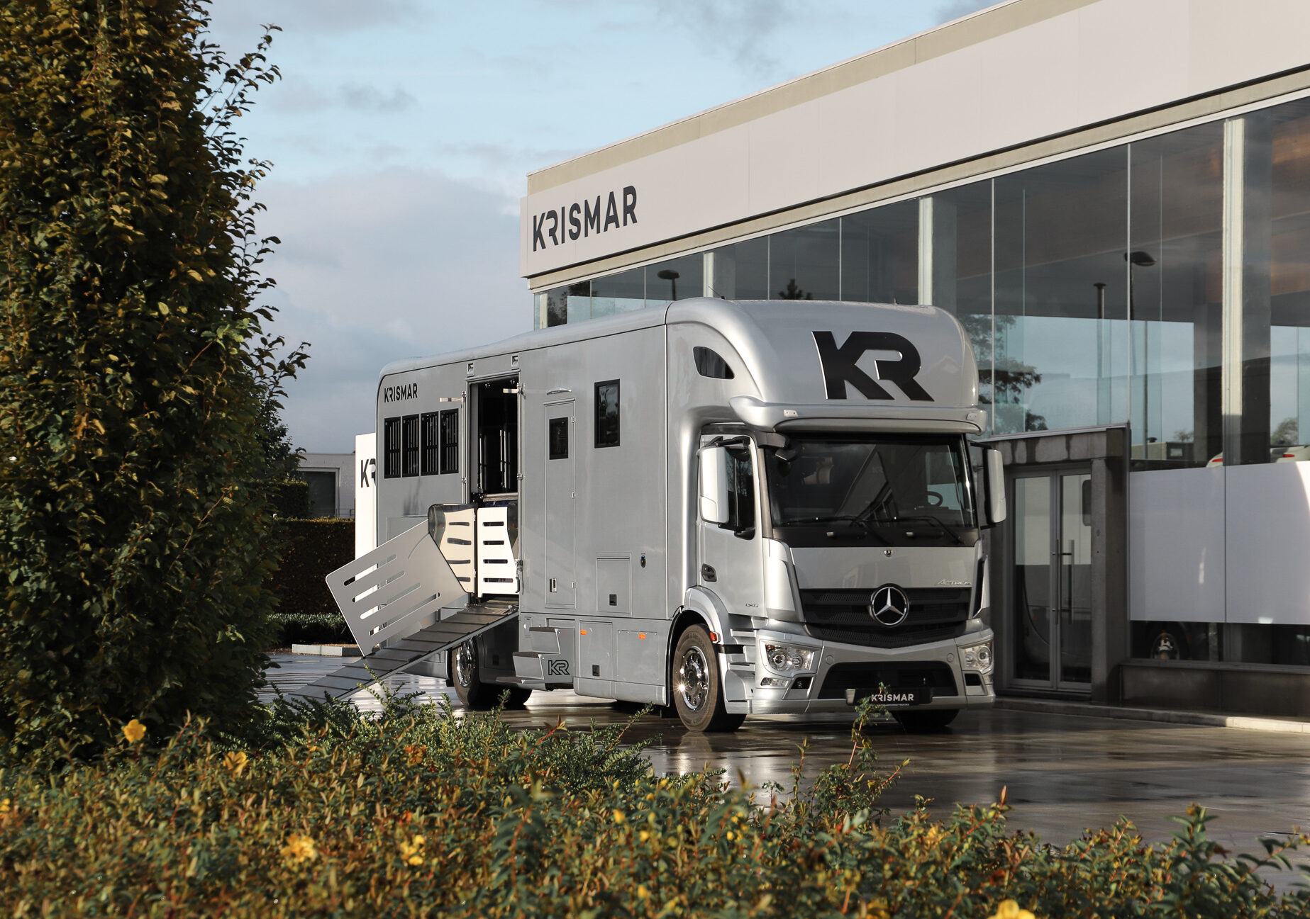 Een lichtgrijze Krismar paardenvrachtwagen op een Mercedes chassis.