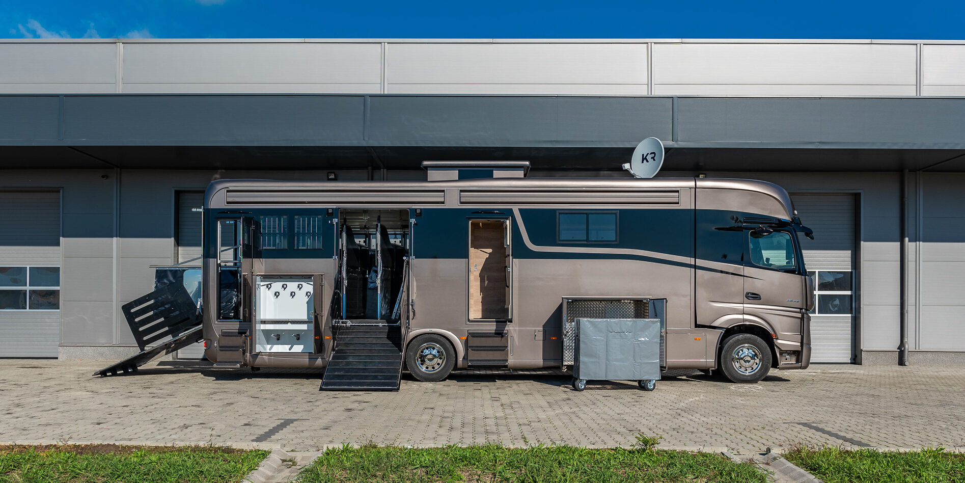 The sideview from a brown horse truck with a black optical line with all the doors open.