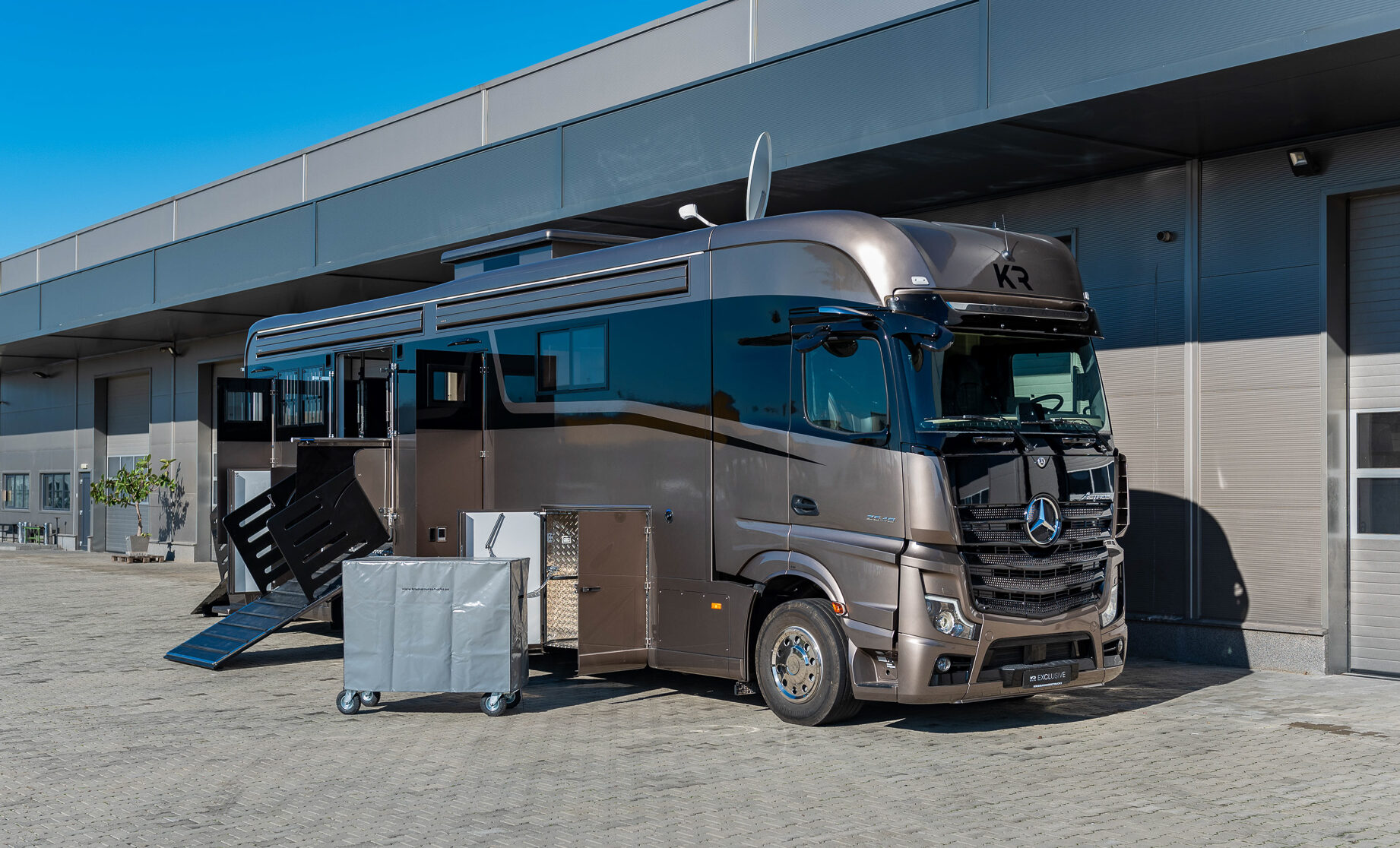 A brown Mercedes horse truck with a tackbox beside.