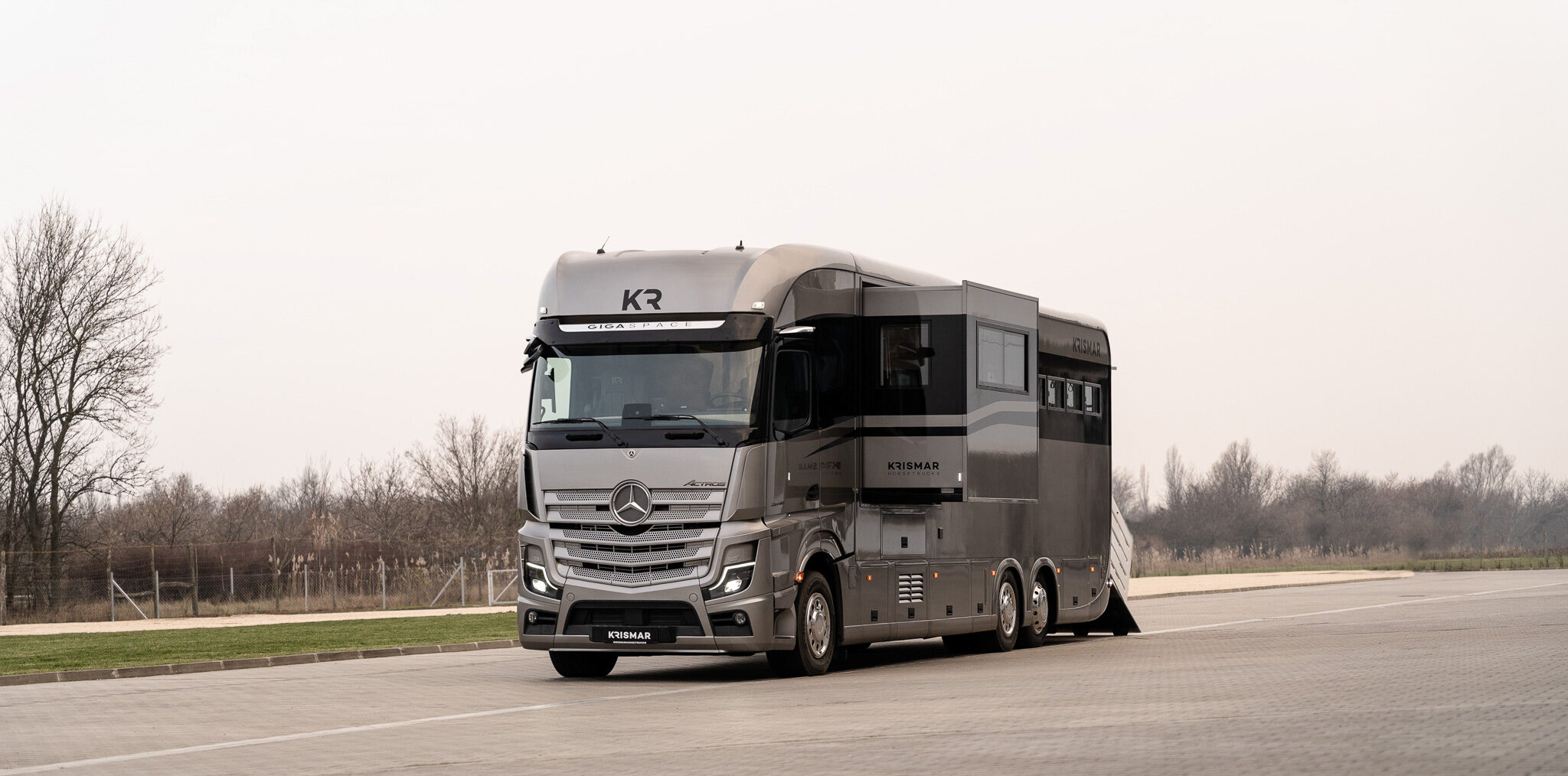 A grey Krismar horse truck with black optical line and pop-out open.