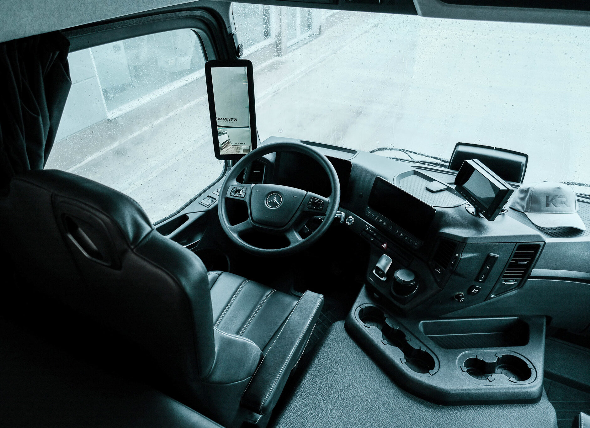 The inside in the drivers cabin of a Mercedes horse truck where you can see the steering wheal. 