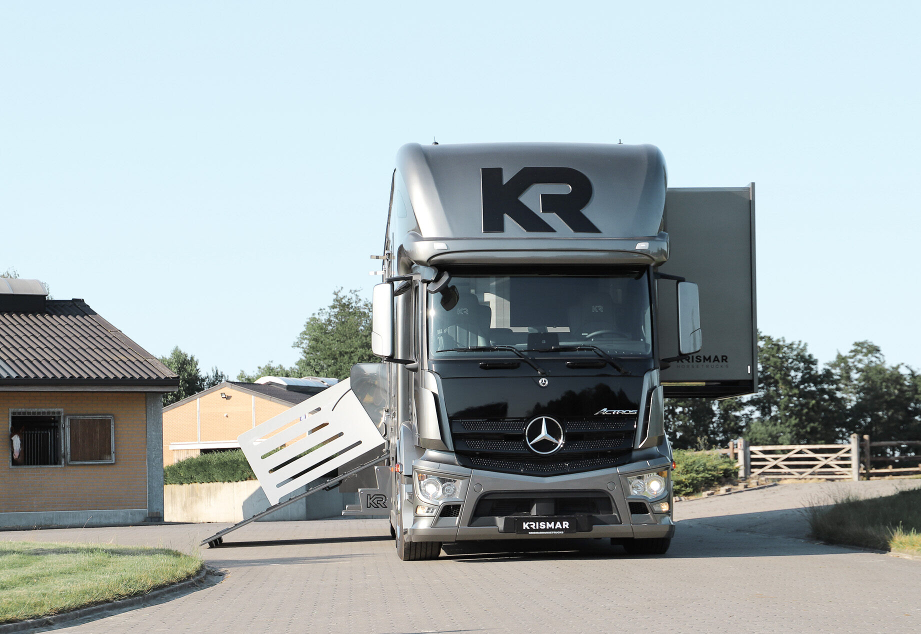 The front of a grey horse truck with pop-out open.