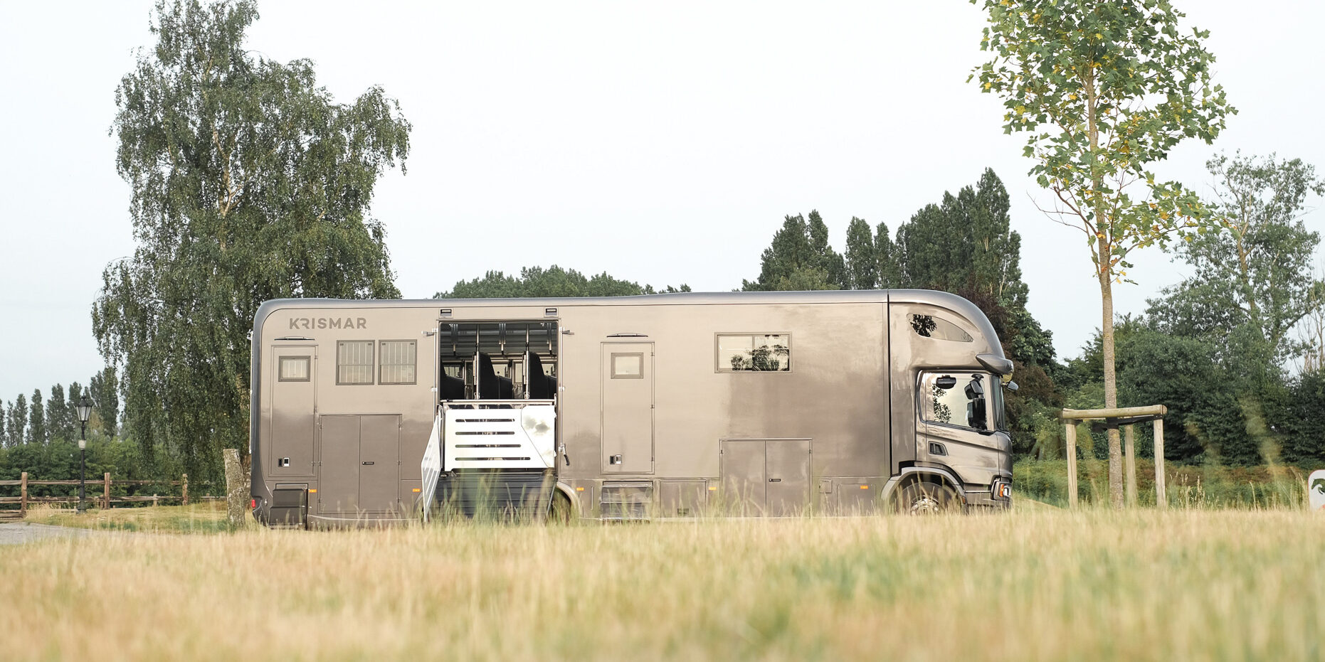 Een bruine Krismar paardenvrachtwagen die plaats biedt aan 6 paarden maar ook beschikt over een volledig uitgerust woongedeelte.