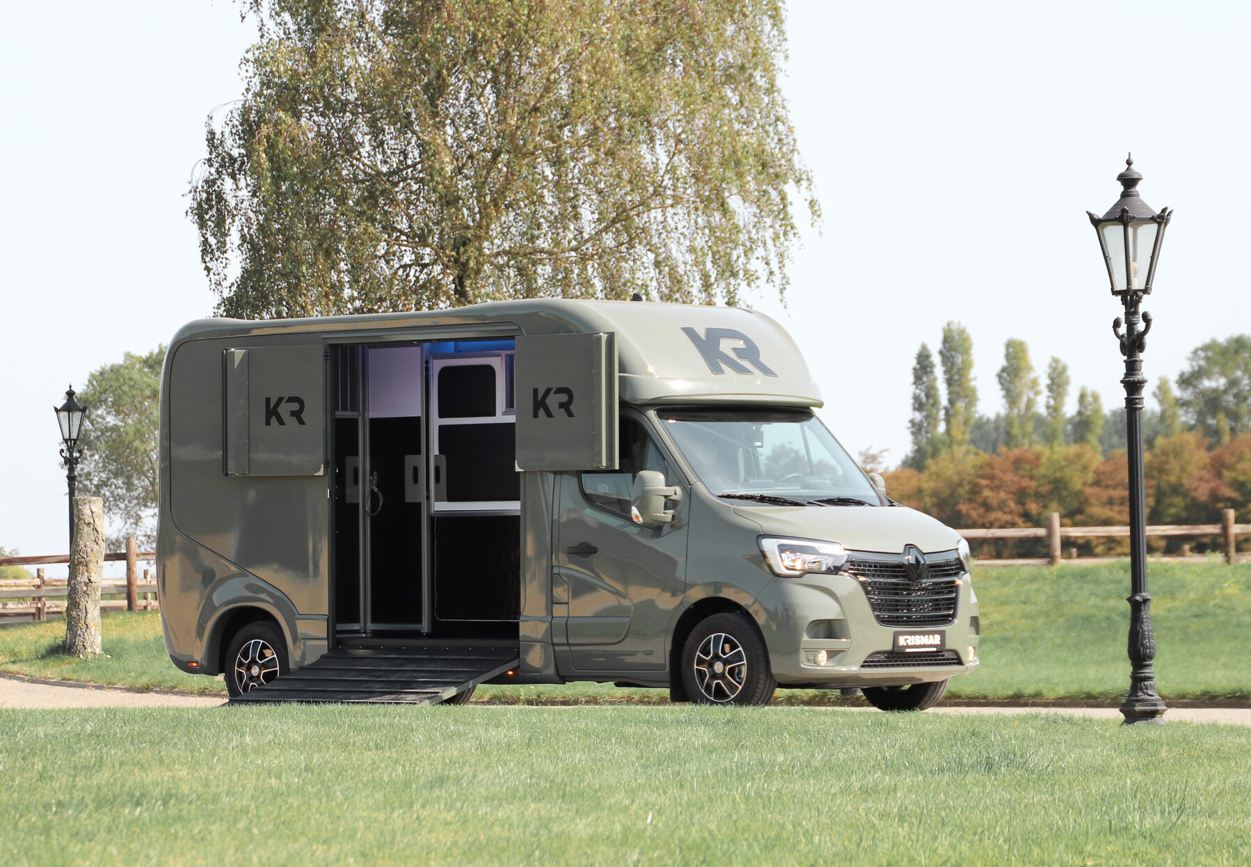 Beautiful green 2-horse camionette with the loading ramp open so you can see the horse part in stallion design.