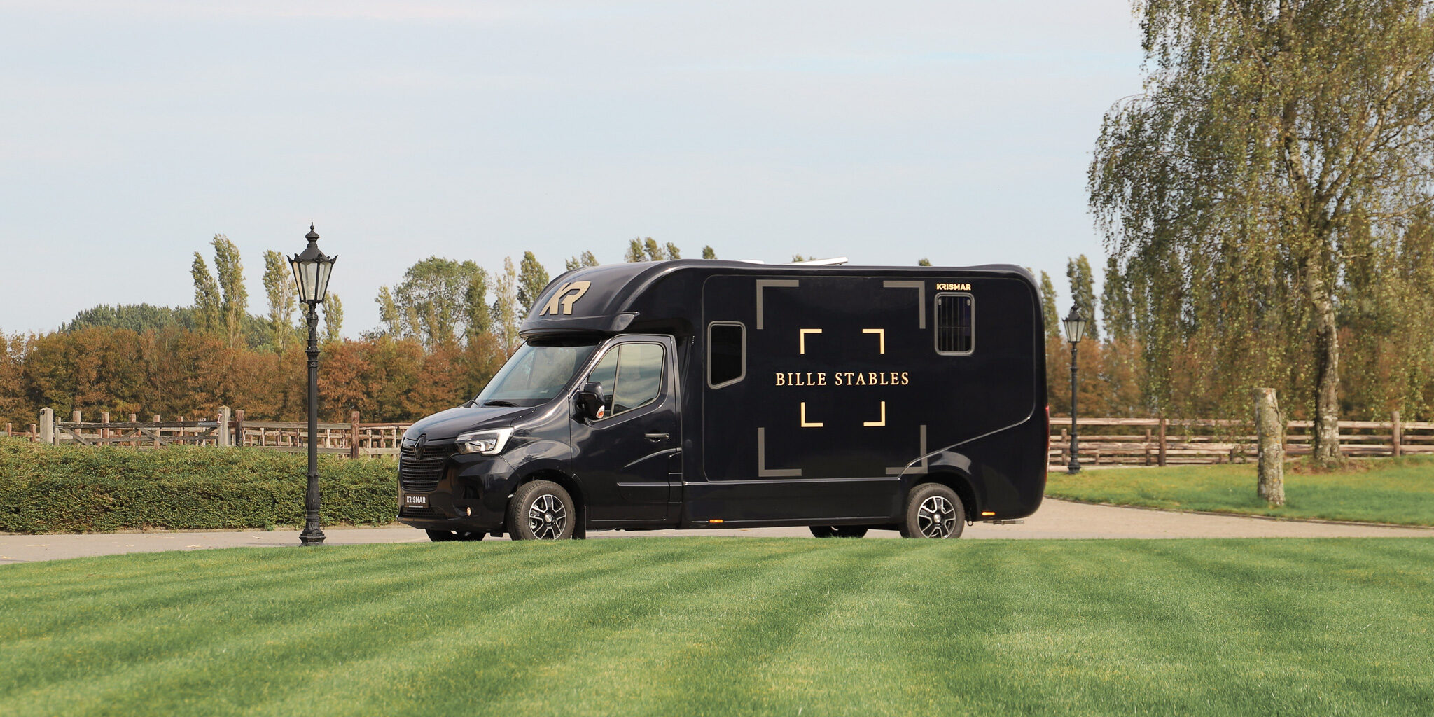 Side view from a gorgeous dark blue Krismar 2-horse with golden logo's on.